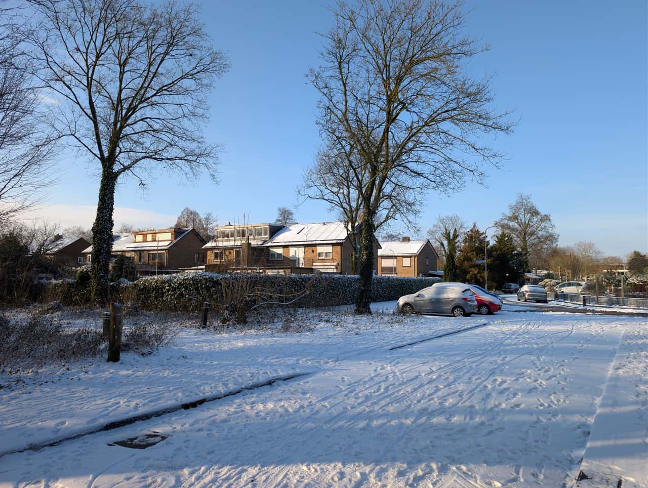 A concrete driveway cleared of snow with banks pushed to either side