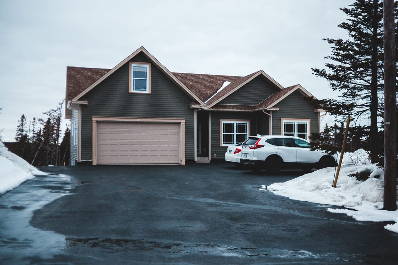 An interlocking paver driveway with snow partially cleared showing the joint pattern