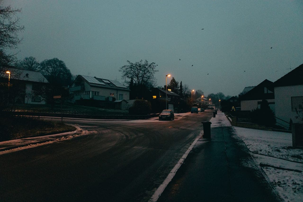 Snow lying undisturbed across a driveway and path at dusk