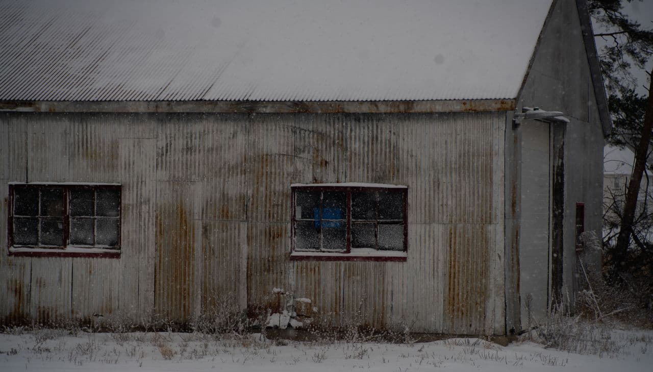 A snow-covered metal roof on a rustic building in winter