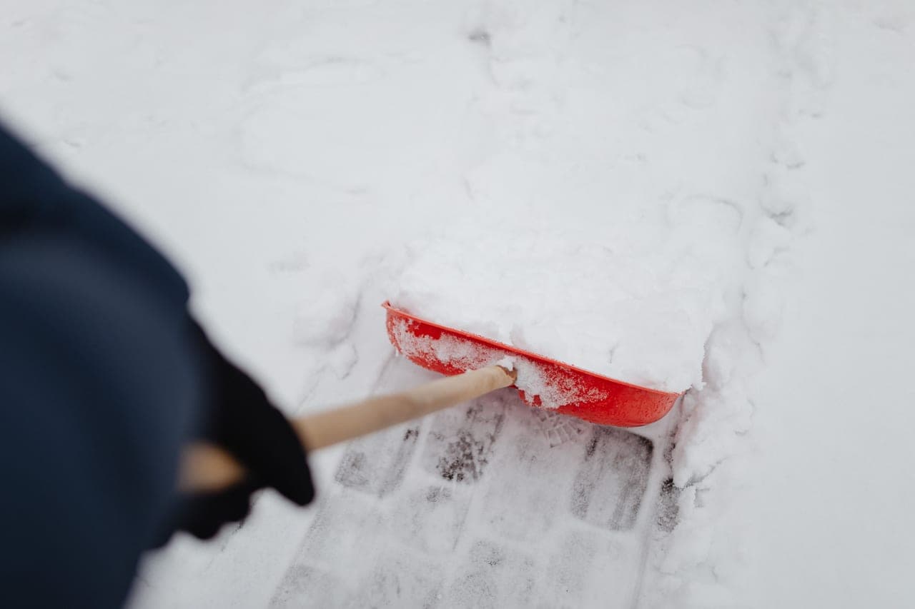 A driveway being cleared in sections, with a straight clean edge to the snow