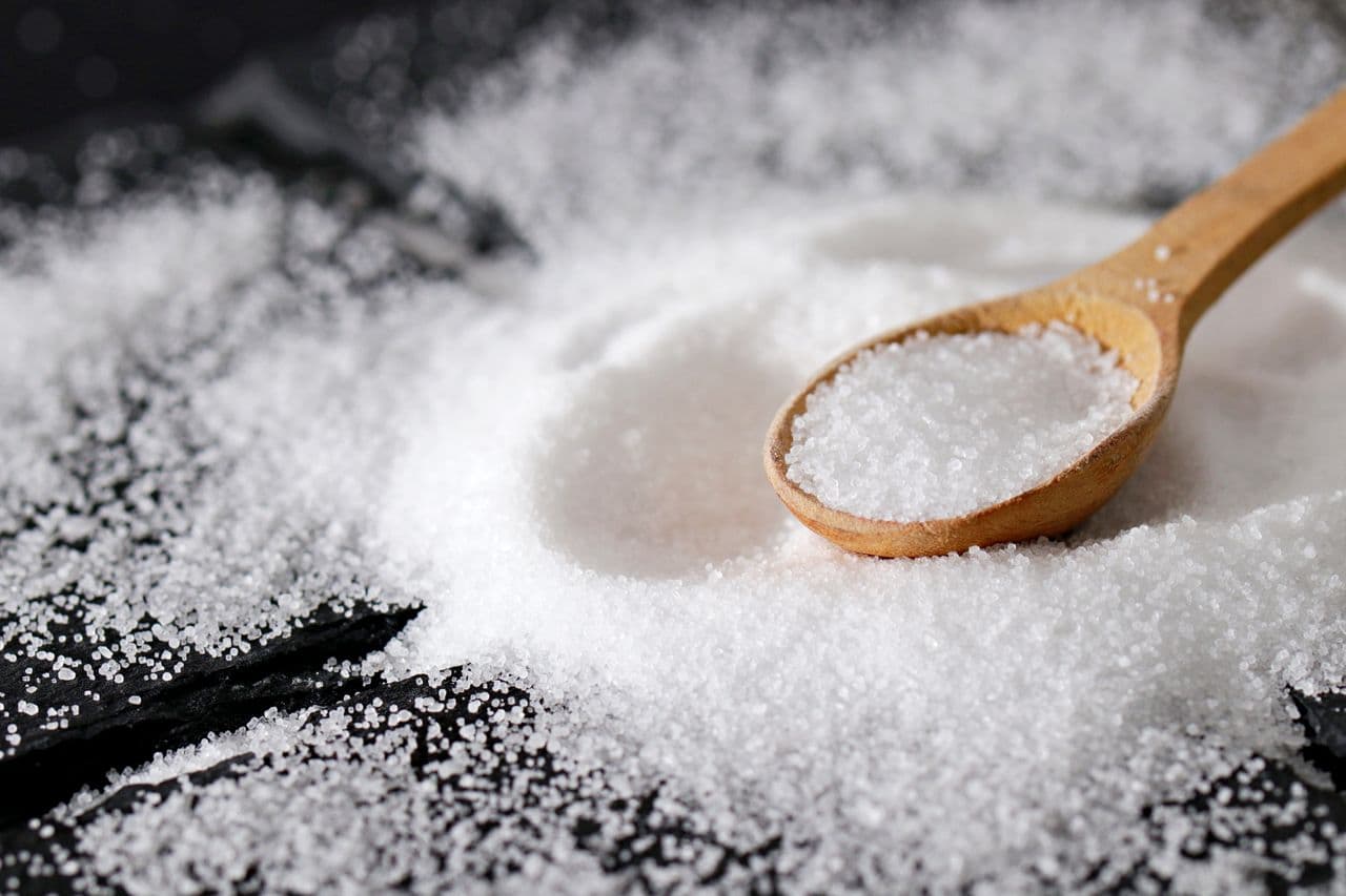 White de-icer granules in a scoop