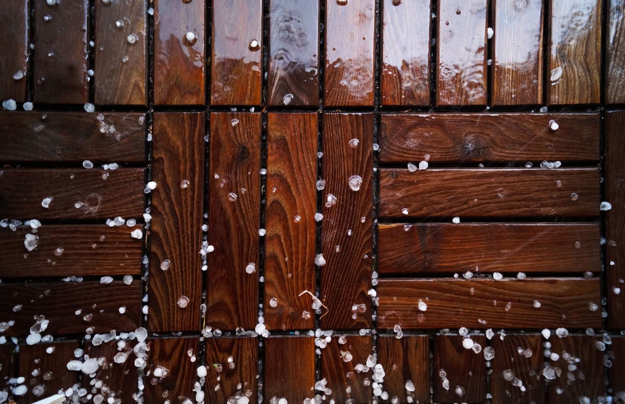 Snow lying on composite deck boards with a partially cleared strip