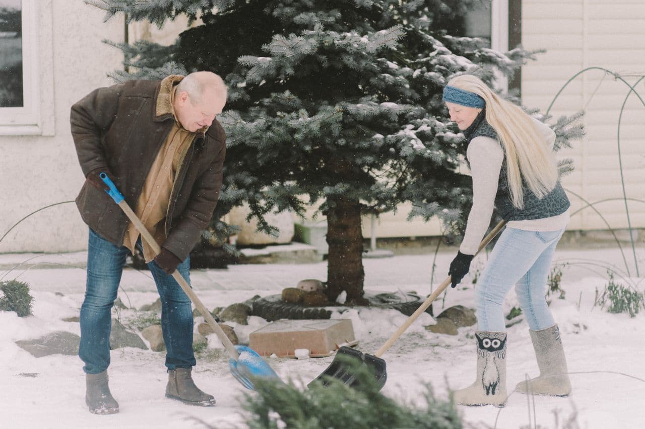 A person clearing light snow from a path in winter