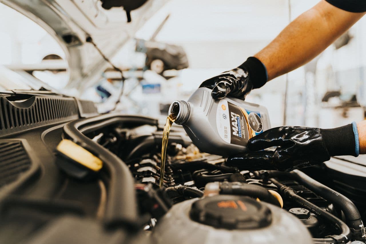 Close-up of engine oil being poured into an engine in a repair shop
