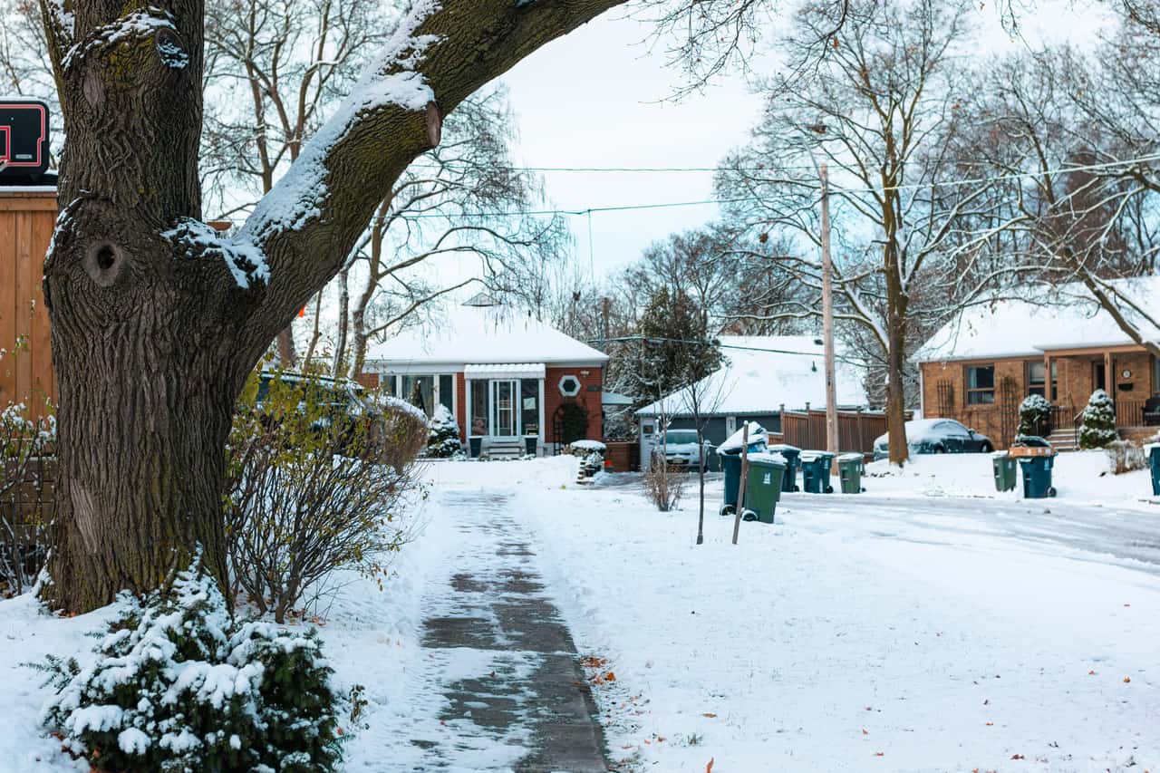 A cleared driveway and front path beside a house after snowfall