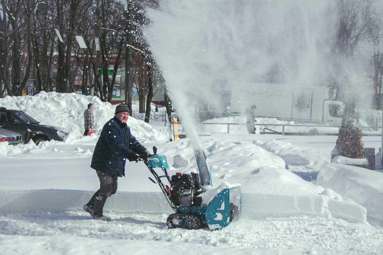 A person operating a snow blower in deep snow