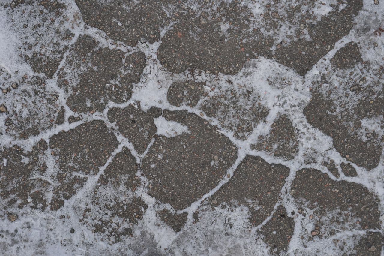 Frozen cobblestone pavement covered in ice and frost