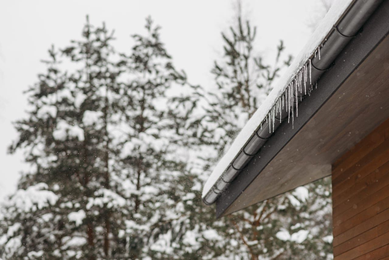 Deep snow sitting on a house roof and eaves in winter