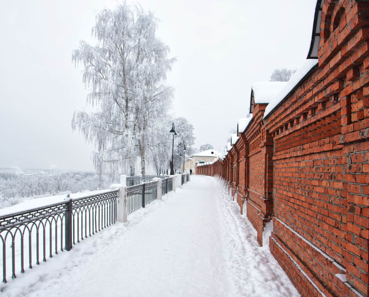 A powered snow shovel clearing a narrow path across a snow-covered walkway